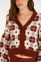 Cardigan de punto con escote en V, cierre frontal con botones y mangas largas abullonadas, con diseño estampado geométrico en tonos marrón, lila y crudo.