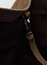 Bolso tipo shopper de piel de serraje, color marrón oscuro, con dos asas de hombro y cierre de botón magnético.