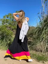 Vestido largo negro con volados en el ruedo en colores amarillo y fucsia.