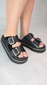 Zuecos de cuero color tostado con plataforma y dos tiras ajustables con hebillas metálicas plateadas.