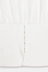Camiseta blanca de algodón con cuello redondo, manga corta y diseño ajustado en la cintura tipo corset.