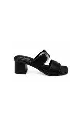 Sandalias de taco medio ancho, color negro, con dos tiras cruzadas en el empeine, punta cuadrada y una hebilla metálica decorativa.