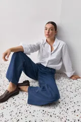 Jean de corte recto y tiro alto, confeccionado en denim azul clásico. Presenta un diseño de pierna amplia con bolsillos funcionales y costuras reforzadas.