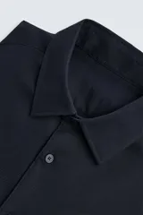 Camisa blanca de manga larga con cuello italiano y cierre frontal de botonadura. Corte regular fit.