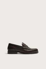 Mocasín de vestir para hombre confeccionado en piel con acabado abatanado, de color marrón. Cuenta con detalle de antifaz en el empeine, horma redonda, plantilla interior de piel y suela a contraste con ligero tacón.
