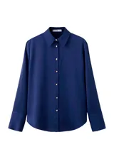 Camisa azul marino de manga larga, con cuello camisero, cierre frontal de botones y puños anchos.