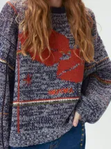 Sweater de punto con diseño geométrico y gráfico frontal en color rojo. Presenta cuello redondo, mangas largas holgadas y un ajuste suelto.