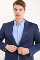 Saco azul oscuro de corte entallado, con solapa de muesca, cierre de dos botones, bolsillo de ribete en el pecho y bolsillos de parche en los laterales.