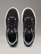 Zapatillas Calvin Klein de estilo urbano con capellada de nailon ripstop reciclado en color negro. Presenta diseño chunky con suela gruesa de TPR en color blanco, cordones técnicos y monograma CK distintivo en el lateral y la lengüeta.