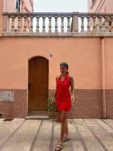 Vestido corto rojo con cuello polo, cierre frontal con cremallera y diseño calado.