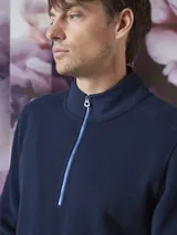 Buzo de frisa azul marino con cuello alto y cierre metálico azul.