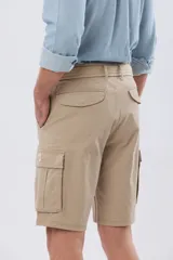 Bermuda cargo color azul marino, de gabardina con bolsillos laterales con solapa en las piernas y presillas para cinturón. Incluye cinturón de lona trenzada oscura con detalles en cuero sintético y hebilla metálica.