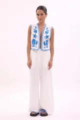 Chaleco blanco con bordados de motivos marinos en azul.