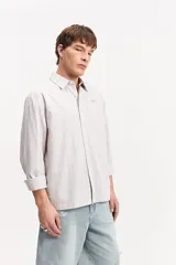 Camisa de manga larga con diseño a rayas verticales en color verde y blanco, cuello clásico y estampa con bordado en la espalda con la frase "Expect Nothing, appreciate everything".