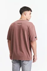 Remera negra de manga corta con corte oversize y cuello redondo. Presenta un estampado pequeño en la espalda con texto en naranja y blanco que dice "Free Spirits Freedom & Waves All Day / Every Day".