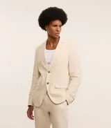 Saco de traje masculino confeccionado en mezcla de lino y viscosa, con cierre frontal de dos botones, bolsillos laterales con solapa y medio forro interior.