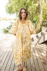 Vestido camisero amarillo con estampado de flores blancas, cuello a la base y manga al codo.