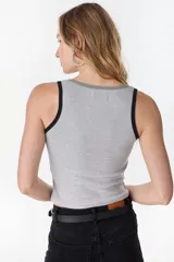 Musculosa de algodón color beige con ribetes naranjas en el cuello y sisas, corte ajustado y diseño acanalado.