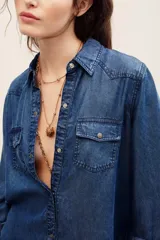 Camisa de denim gris oscuro efecto acid wash, de manga larga, con bolsillos frontales con solapa y broches metálicos a presión.