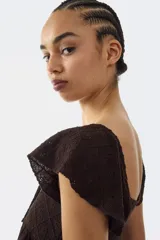 Blusa marrón de punto pointelle con textura, escote corazón, detalle cut-out con cordón de ajuste en el busto, mangas cortas circulares con volados y diseño acampanado.