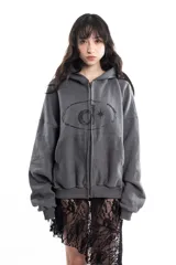 Campera gris de algodón con cierre frontal, capucha y bolsillos tipo canguro. Tiene costuras a la vista, remaches y bordado.