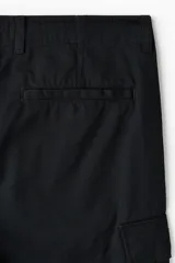 Pantalón cargo negro de sarga de algodón, con bolsillos laterales con solapa en las perneras y corte relajado.