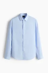 Camisa celeste de corte slim fit, con cuello inglés y cierre frontal de botones.