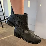 Bota de caña media confeccionada en cuero vacuno con efecto desgastado. Presenta elásticos laterales para un calce cómodo, taco de madera y suela de caucho.