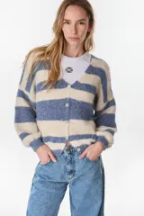 Cardigan de punto a rayas horizontales en tonos crudo y azul, con cuello en V, mangas largas abullonadas y cierre frontal de botones.
