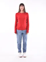 Sweater rojo de tejido de punto liso, con cuello redondo y mangas largas con leve frunce en los hombros.