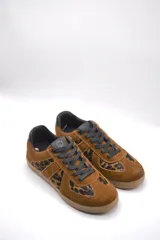 Zapatillas urbanas de cuero color crema con puntera y talón en gamuza gris, suela de goma marrón y cordones grises.