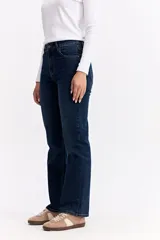 Jean de corte recto y tiro medio, confeccionado en denim de tono azul claro con acabado lavado. Presenta cierre frontal con botón y cremallera, además de bolsillos laterales y traseros.