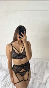 Conjunto de lencería compuesto por un bralette de encaje con tiras decorativas y una bombacha tipo portaligas con detalles en encaje y microtul.