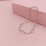 Pulsera de cadena de eslabones ovalados en plata 925, con tres eslabones centrales decorados con circonias engastadas. Incluye cierre de mosquetón y cadena de alargue.