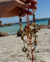 Collar con dije de bronce macizo con forma orgánica irregular, similar a un coral, suspendido de un cordón negro de seda natural anudado.