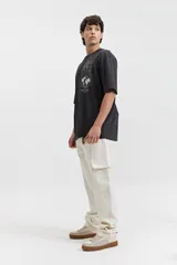 Jean cargo negro de tiro medio, con pasacinto, bolsillos laterales y bolsillos cargo con solapa en los muslos.