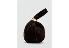 Bolso de mano pequeño confeccionado en terciopelo color marrón oscuro, con diseño fruncido y detalle de aro metálico dorado en el asa.
