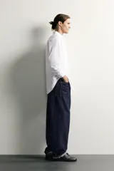 Camisa de corte slim fit confeccionada en tejido de fácil planchado, con cuello italiano, manga larga con puños abotonados y cierre frontal de botones.