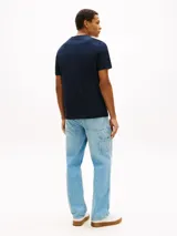 Remera de punto azul marino de manga corta y cuello redondo, confeccionada en puro algodón. Presenta un logo gráfico estampado en el pecho con las inscripciones "Tommy Hilfiger American Classics Est. 1985".