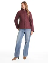 Campera capitoneada azul marino con diseño de rombos y paneles laterales elásticos para un ajuste entallado. Presenta cuello alto, cierre frontal completo y bolsillos laterales con cierre.