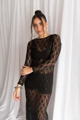 Vestido midi negro confeccionado en encaje transparente, de manga larga y silueta ajustada.