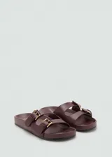 Sandalias planas color borravino con doble tira ancha en el empeine y hebillas metálicas doradas.