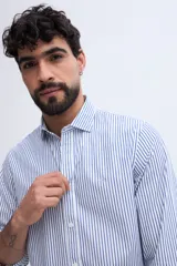 Camisa de manga larga fit semi slim color celeste, con cierre frontal de botones y cuello camisero clásico.
