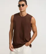 Musculosa básica de hombre, color blanco, con cuello redondo, sin mangas y pequeña etiqueta aplicada en el bajo.