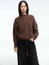 Sweater de tejido de punto con textura suave y acabado ligeramente afelpado, de corte holgado, cuello redondo y mangas largas.