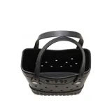 Bolso tipo tote Crocs color negro, fabricado en material sintético perforado con detalles texturizados en la base, doble asa superior y logo de la marca en relieve en el frente.