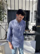 Camisa de hombre de algodón con estampado a cuadros en tonos rosado y celeste, corte clásico, manga larga, bolsillo en el pecho y botón en el cuello.