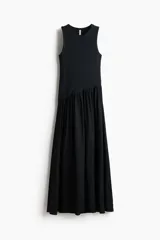 Vestido midi negro sin mangas, con cuello redondo y diseño ajustado en la parte superior de punto acanalado. Cuenta con una costura fruncida en diagonal bajo la cintura y una falda larga con vuelo de tejido fluido.