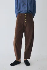 Pantalón de corte barrel en pana color azul marino, con cierre frontal de botones metálicos dorados a la vista y costuras reforzadas en las rodillas.