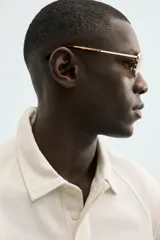 Polo de manga larga color crema, confeccionado en tejido de algodón, con cuello solapa y cierre frontal de botonadura. Presenta un calce relajado y acabados en rib en puños y ruedo.